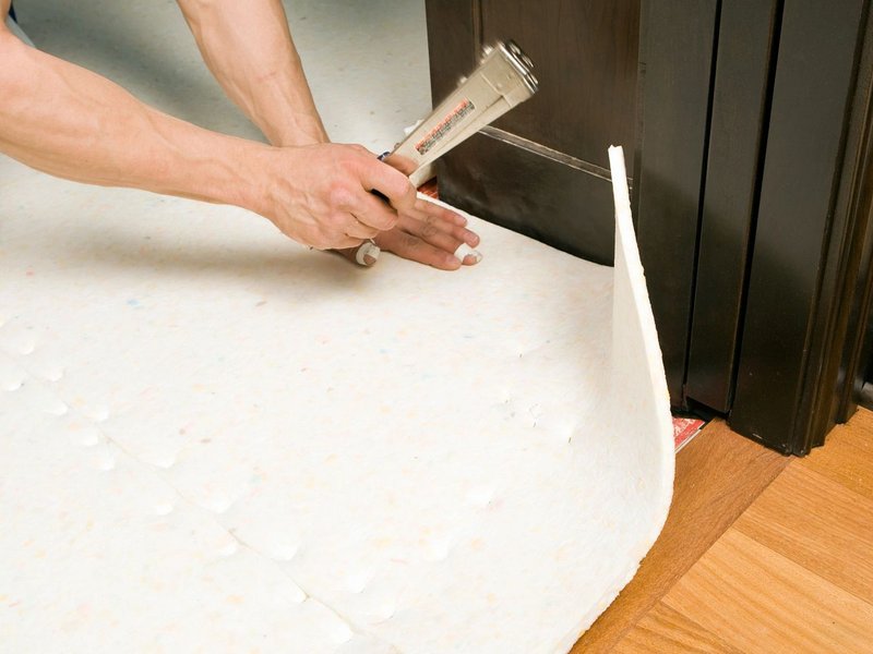 Person installing flooring underlayment from Wholesale Flooring and Blinds in Casper, WY