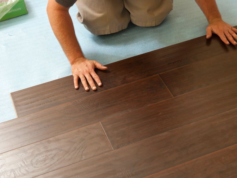 Person installing hardwood flooring - Flooring installation services from Wholesale Flooring and Blinds in Casper, WY